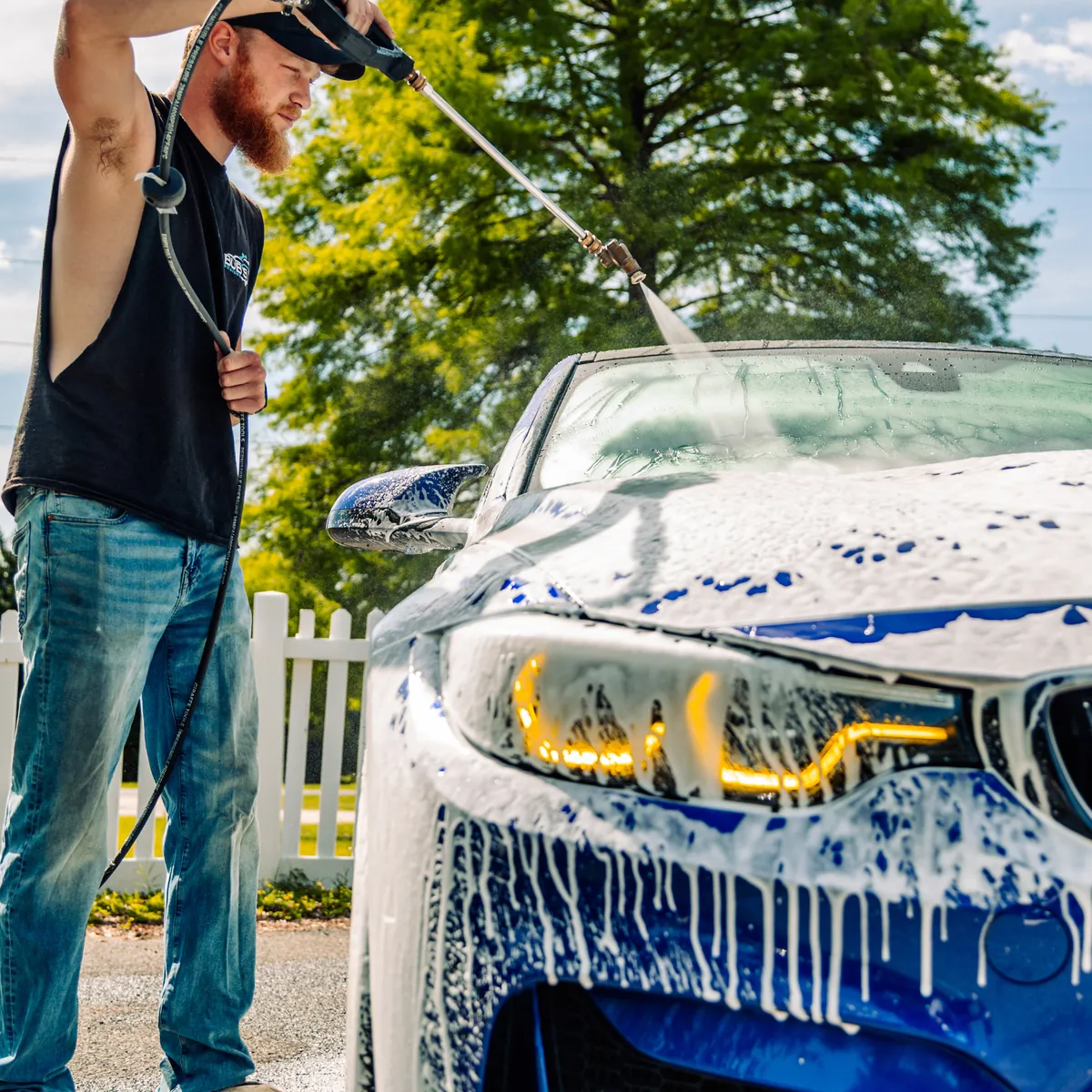 Blue BMW M4 covered in foam during the wash stage